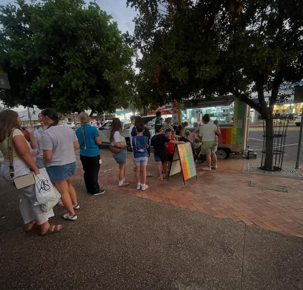 Ice cream truck at night market with huge line of customers